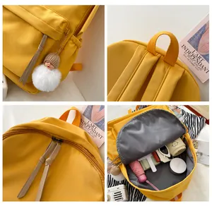 Detail view of bright yellow backpack showing interior storage and plush charm
