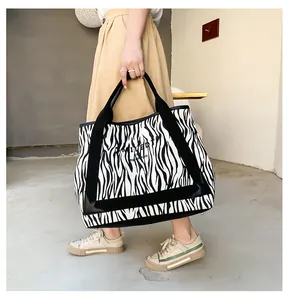 Détail du sac cabas en toile zébrée avec des anses noires et une grande contenance