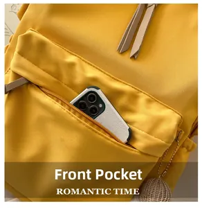 Close-up of the front zipper pocket on a yellow canvas backpack with a smartphone