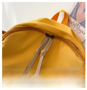 Detail of high-quality smooth dual metal zippers on a yellow canvas backpack