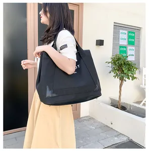 Détail du sac cabas en toile noire avec coins en cuir renforcés et logo Paris blanc