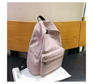 Vista detallada de la mochila de nailon rosa con compartimentos en una silla vintage