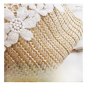 Close-up of woven straw bucket bag with white lace floral pattern and raffia texture