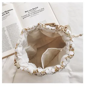 Detailed top view of straw bucket bag featuring white lace trim and interior pocket