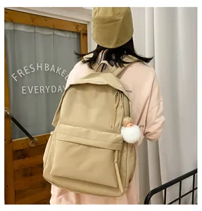 Minimalist khaki nylon backpack for students featuring a large main bag and plush charm
