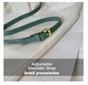 Detalle de la correa ajustable de cuero con hebilla de metal dorado y costuras