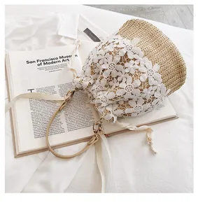 Detail of lace flower straw bucket bag with drawstring closure and crossbody strap