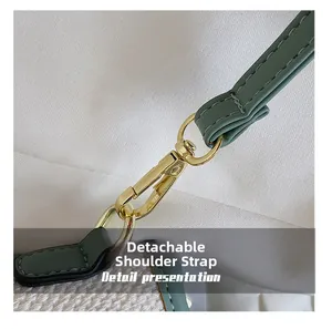 Detalle de correa desmontable de cuero verde con cierre de mosquetón dorado en el bolso