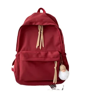 Minimalist burgundy waterproof nylon backpack for women with cute doll charm and ribbon