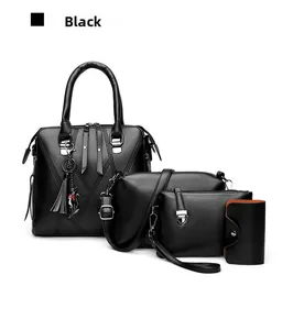 Detail view of four-piece black leather bag set including tote with tassel charm