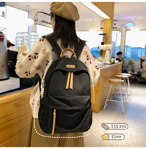 Close-up of waterproof black nylon backpack with brown leather tags and fashion patch
