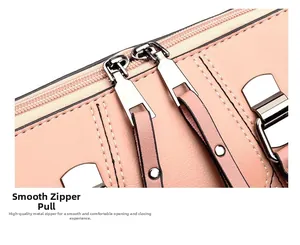 Detail of pink pebbled leather bag featuring smooth dual silver zippers and tassel pulls