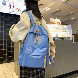 Minimalist light blue large capacity backpack for women shown from back view on model
