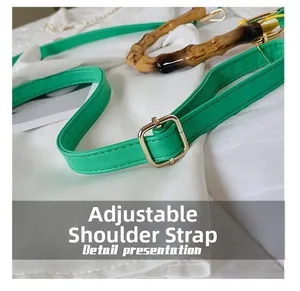 Détail de la bandoulière en cuir vert avec boucle dorée et poignée en bambou