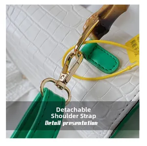 Détail de la bandoulière verte amovible avec boucle dorée et poignée en bambou du sac