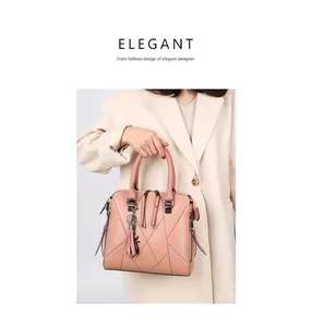 Close-up of pink leather handbag featuring geometric quilting and cute cat tassel charm