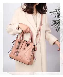 Fashionable pale pink handbag featuring quilted diamond pattern and metallic cat charm