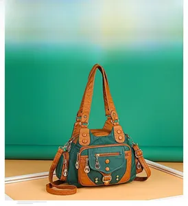 Detail of soft leather crossbody bag featuring multi-pocket design and woven handles