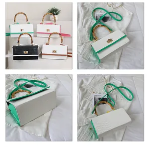 Détail de la poignée en bambou et du motif crocodile sur le sac box bicolore rétro