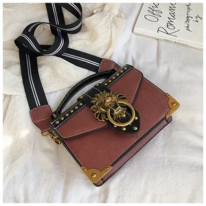 Detail of vintage brown leather bag with golden lion head lock and studded accents