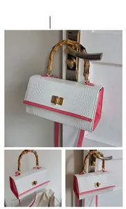 Détail de la poignée en bambou et du cuir rose motif crocodile sur un sac rétro chic