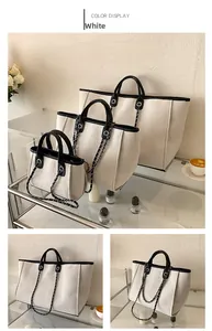 Comparación detallada de tres tamaños de bolsos tipo cubo en lona crema con bordes de cuero