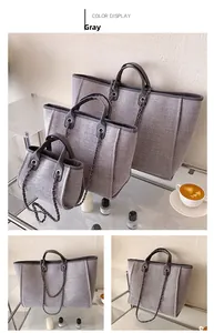 Juego de tres bolsos cubo grises con textura tejida, cadenas y detalles metálicos