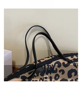 Détail de la texture léopard en toile avec poignée noire et rivets métalliques