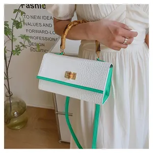 Vue détaillée du petit sac à motif crocodile avec poignée en bambou et fermoir rotatif