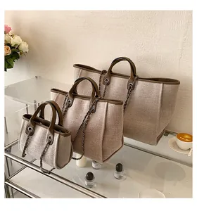 Detailset aus drei Canvas-Eimertaschen mit braunem Lederbesatz und silbernen Kettenriemen