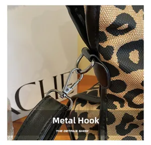 Détail du crochet métallique sur sac en toile léopard avec finitions chics en métal