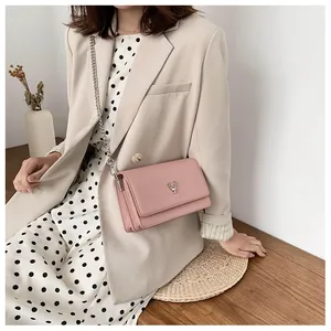 Détail du sac bandoulière en cuir rose avec tête de cerf argentée et chaîne métal