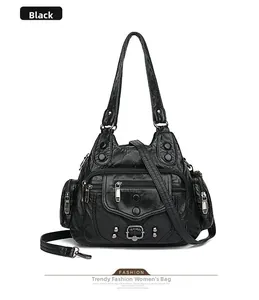 Close-up of black washed leather handbag featuring functional multi-zipper pockets and studs