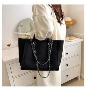 Detailansicht der großen schwarzen Canvas-Tasche mit Silberkette in Lifestyle-Szenerie