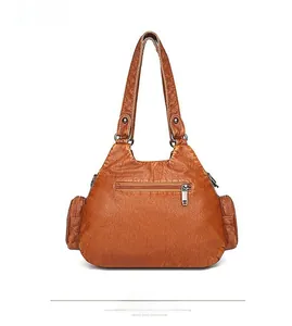 Close-up of the back side of a vintage brown soft leather shoulder bag with zipper pockets