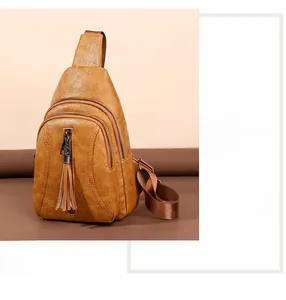 Dettaglio della borsa a tracolla color caramello con texture vintage e frange