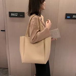 Minimalist beige tote bag in matte leather featuring large capacity for daily commuting