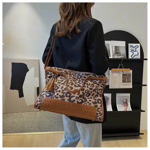 Détail du sac cabas léopard avec clous métalliques et accessoire à franges stylé