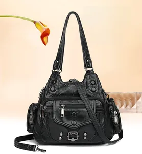 Detail view of black vintage handbag with multiple zippers and metallic rivet accents