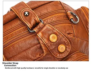 Detail of reinforced hardware rings and bronze zipper on the brown leather crossbody bag