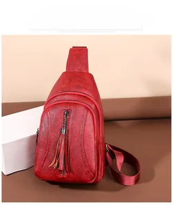 Dettaglio della borsa a tracolla rosso scuro vintage con cerniere e trama morbida lavata