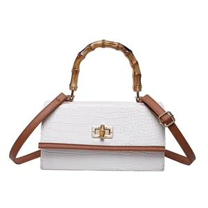Détail du sac en cuir PU blanc à motif crocodile avec poignée en bambou et fermoir doré