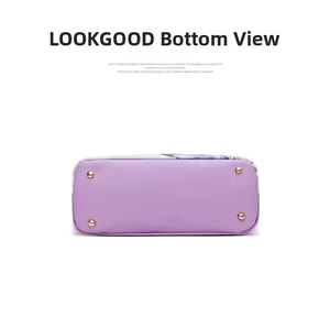 Detailed bottom view of a purple floral bag showing four golden metal protective feet