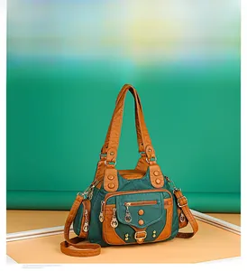 Macro shot of multi-pocket vintage green leather handbag with bronze zippers and rivets