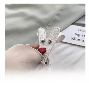 Détail de la bandoulière réglable en cuir grainé avec boucle en métal argenté