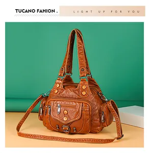 Close-up of brown vintage PU leather bag featuring multiple zipper pockets and soft texture