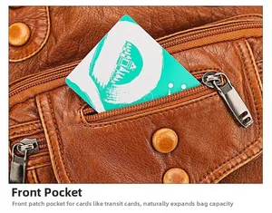 Detailed view of the front pocket on a brown faux leather crossbody bag with zips