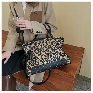 Détail du sac cabas léopard avec clous argentés et accents de pompons en cuir élégants