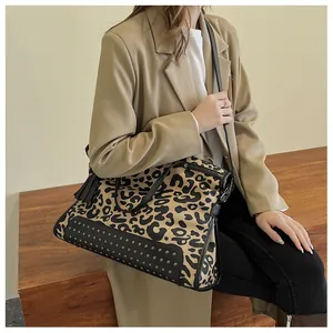 Vue détaillée du sac cabas léopard avec rivets métalliques et anses en cuir noir