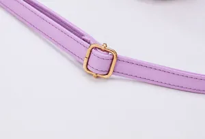 Detail of adjustable golden metal buckle on purple Saffiano textured faux leather bag strap